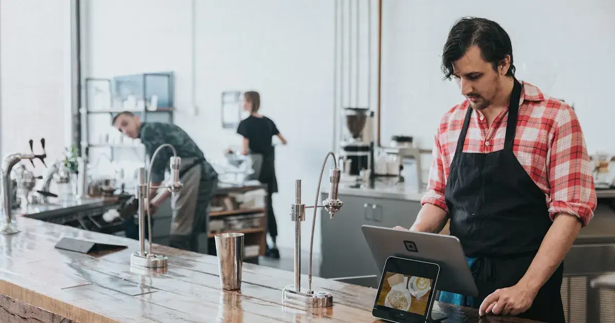 Café owner using a laptop behind the counter